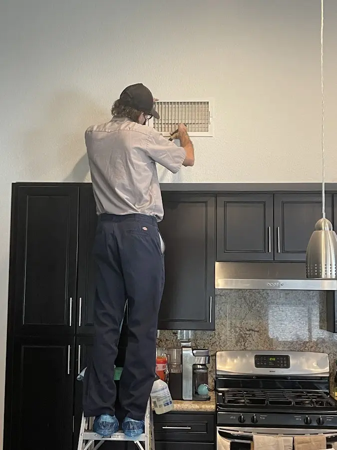 Technician inspecting an air vent during HVAC service in Mansfield